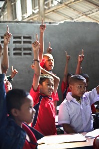 Boys raise hands in classroom