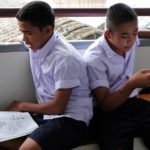 Migrant students studying before an exam.